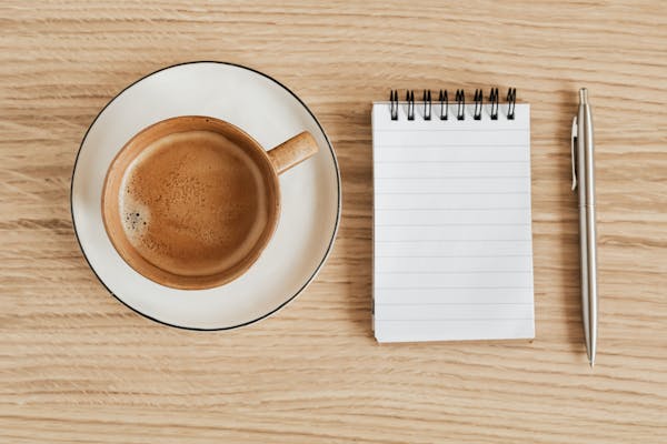 Coffee shop overhead shot of espresso and notebook. 