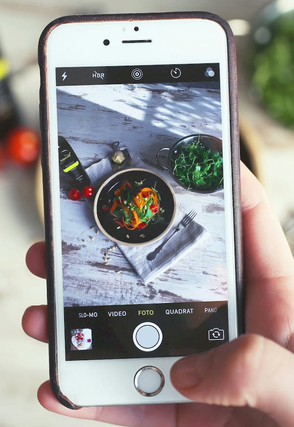 A foodie taking a picture of a meal at a restaurant for Instagram.