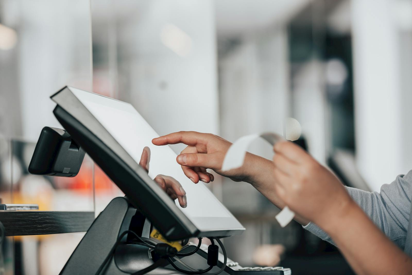 Image of a restaurant staff inputting info into a POS terminal